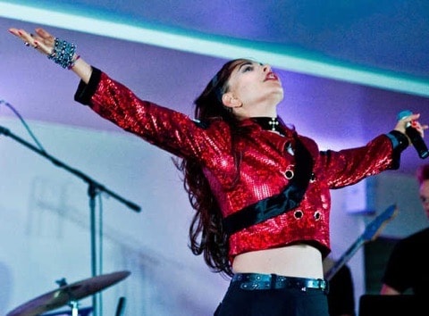 Reesi Rocca performing in red sequin jacket