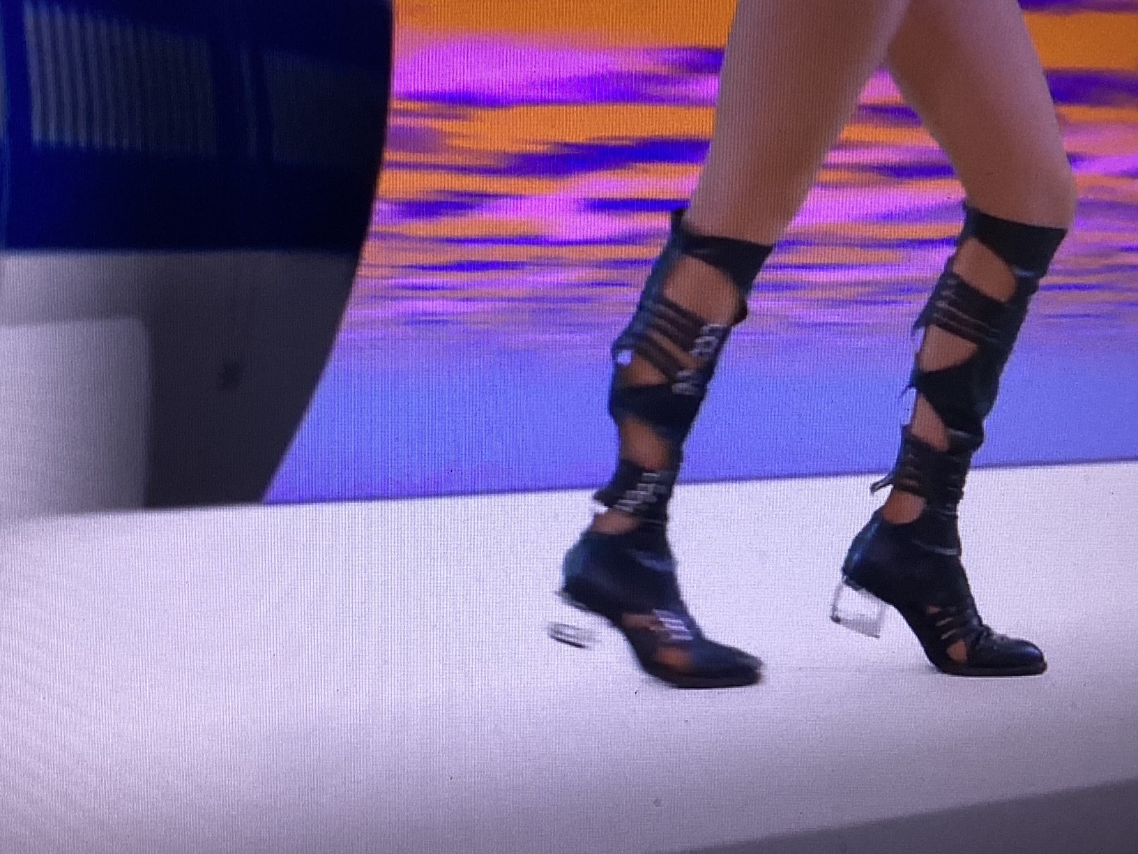 Reesi Rocca's iconic stage boots — close up under purple and orange stage lights